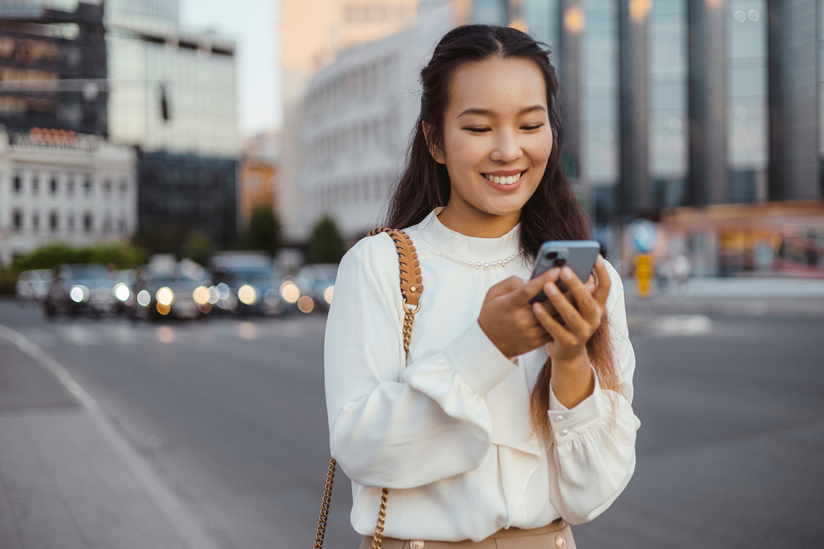 woman using a smartphone on a sidewalk